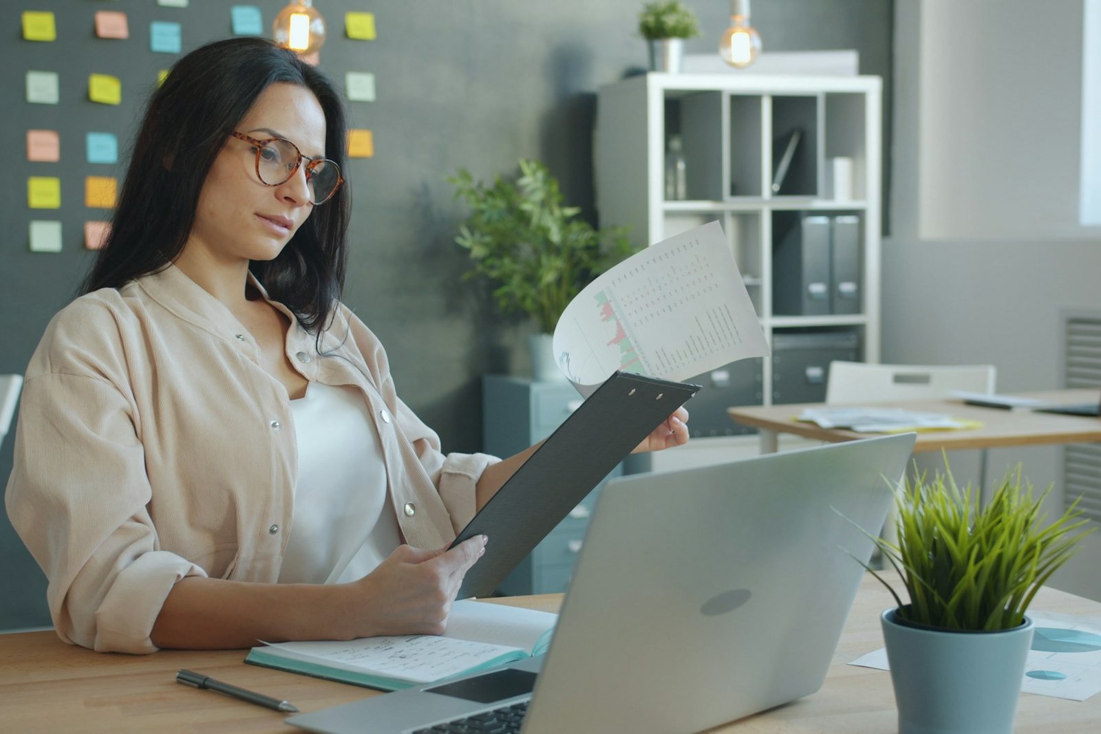 Office worker reviewing documents beside a laptop